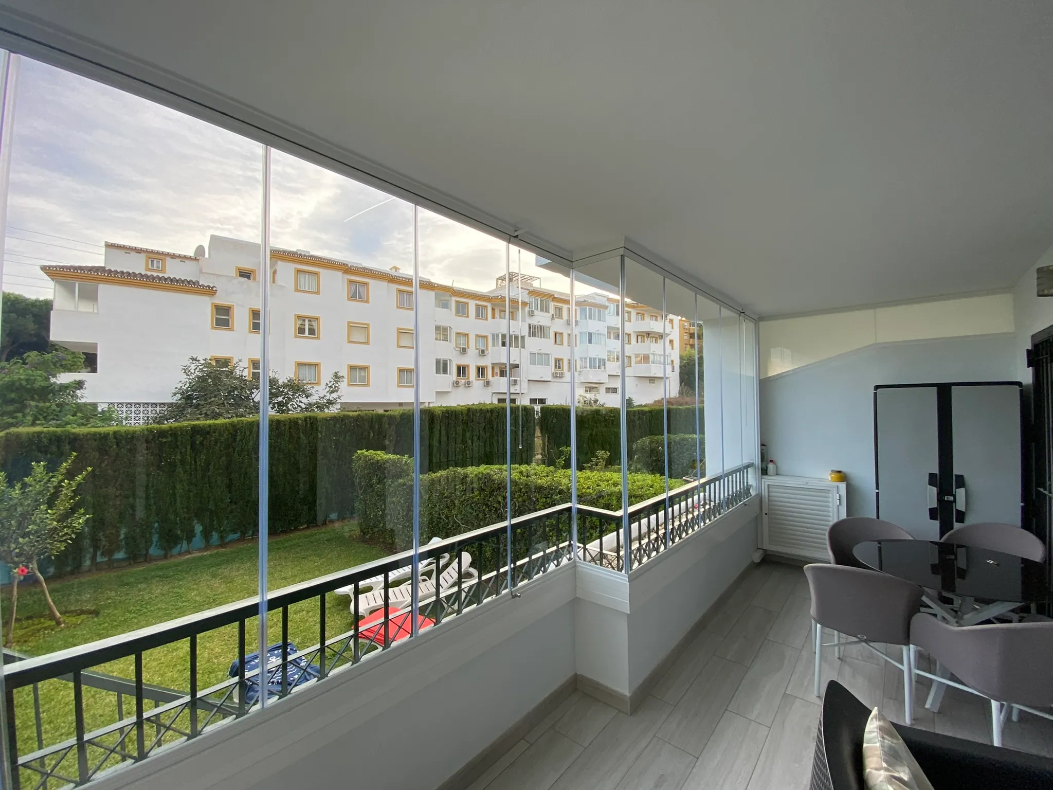 Frameless glass curtains enclosing an apartment terrace in Marbella