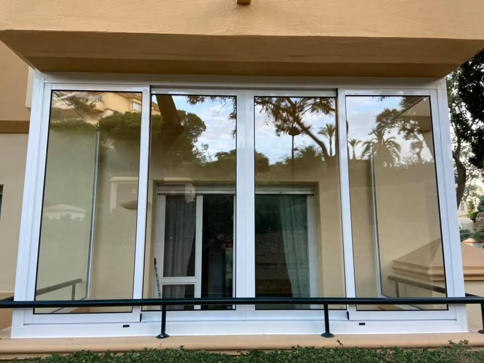 Large white UPVC sliding windows on a ground-floor apartment